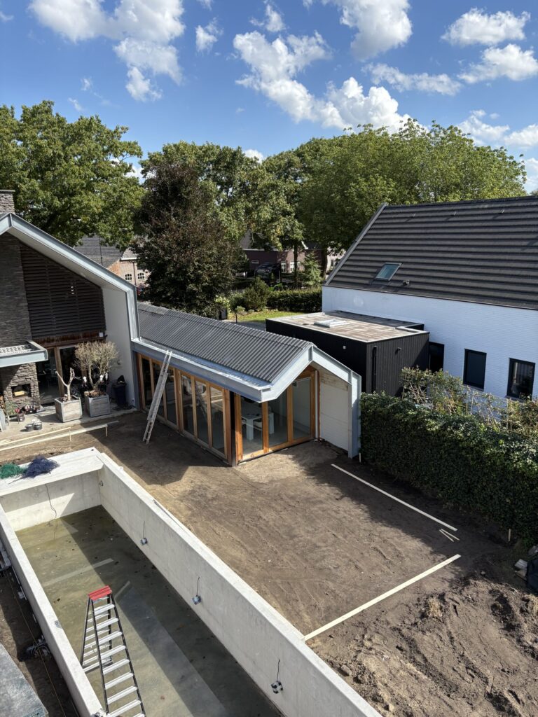 Nieuwe uitbouw met zwart dak, gezien vanaf de bovenverdieping