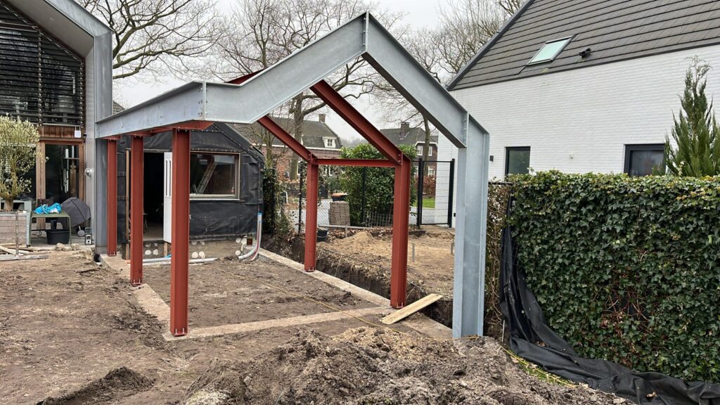 Staalconstructie in de vorm van een huis, in een tuin