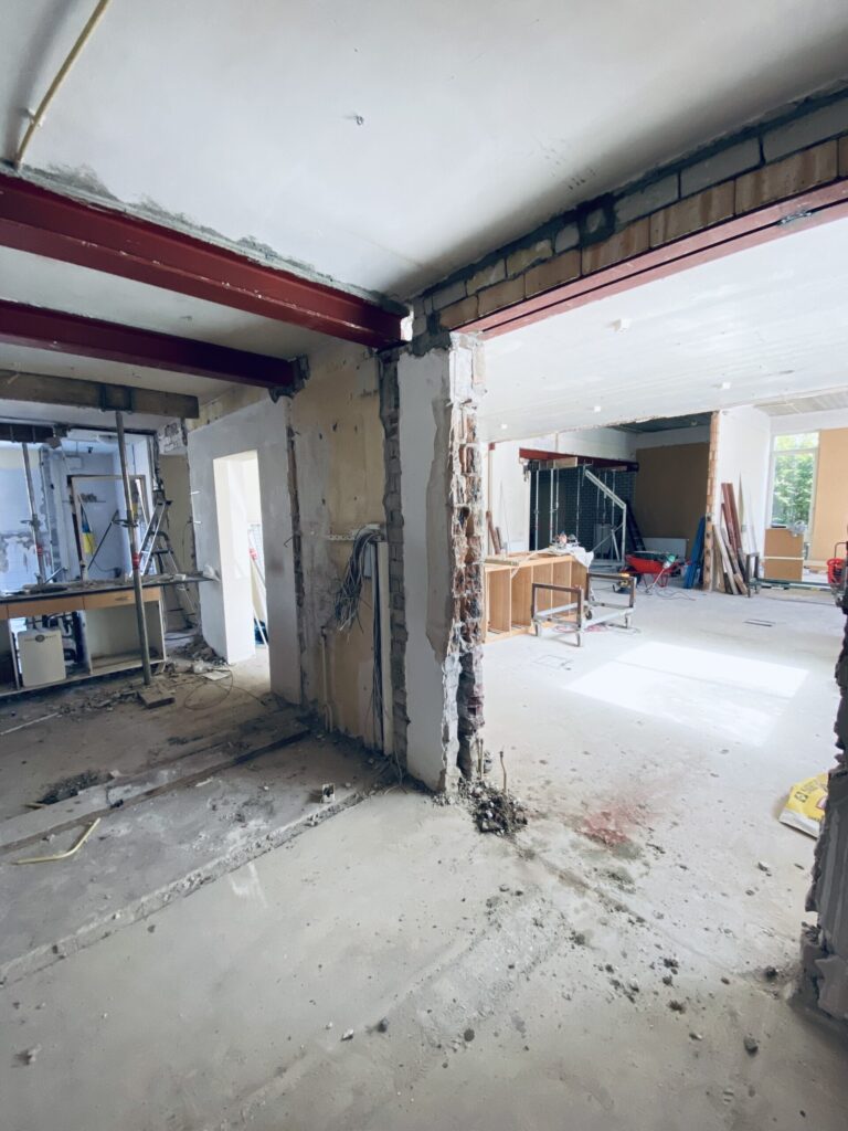 Rood gegronde stalen liggers in een open gesloopte benedenverdieping