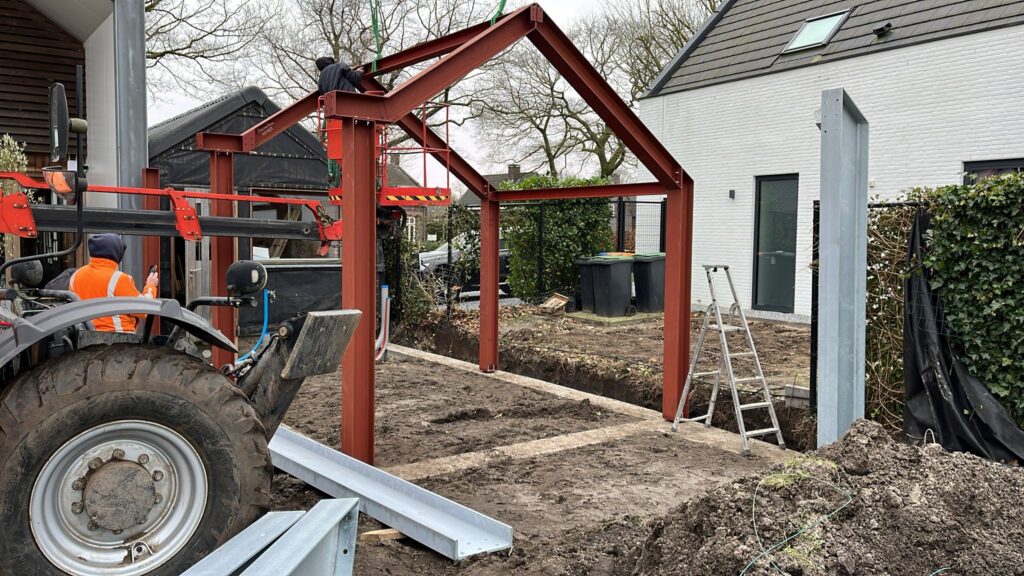 Rood gegronde stalen portalen in een tuin, geplaatst met een kleine kraan